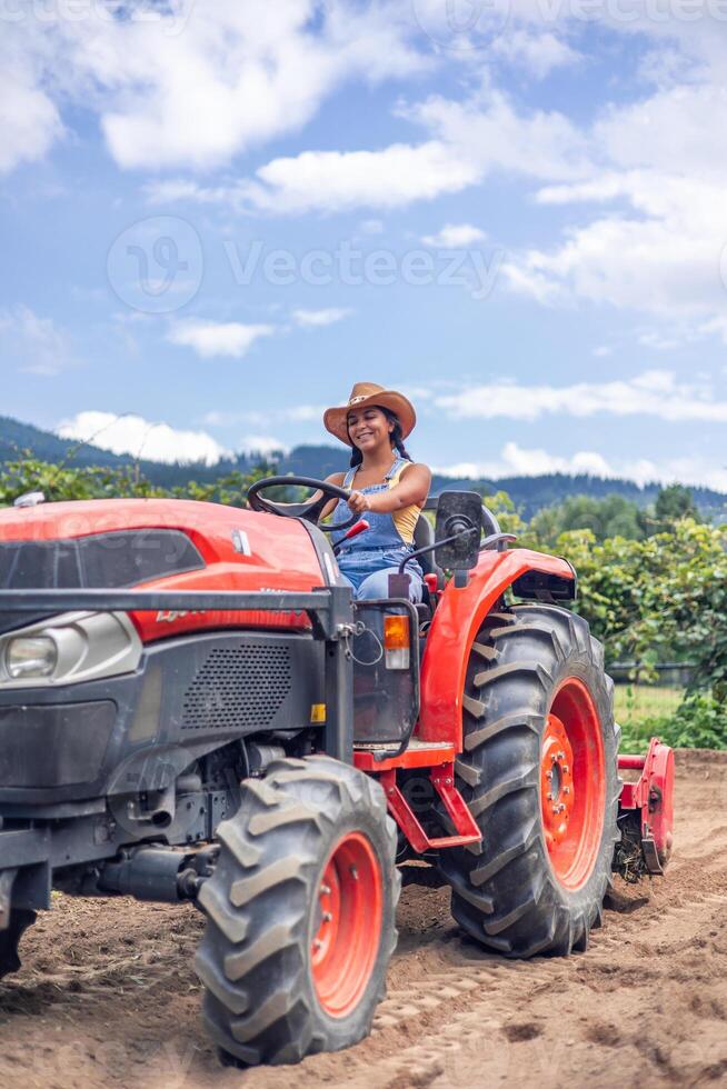 Woman on tractor in field photo