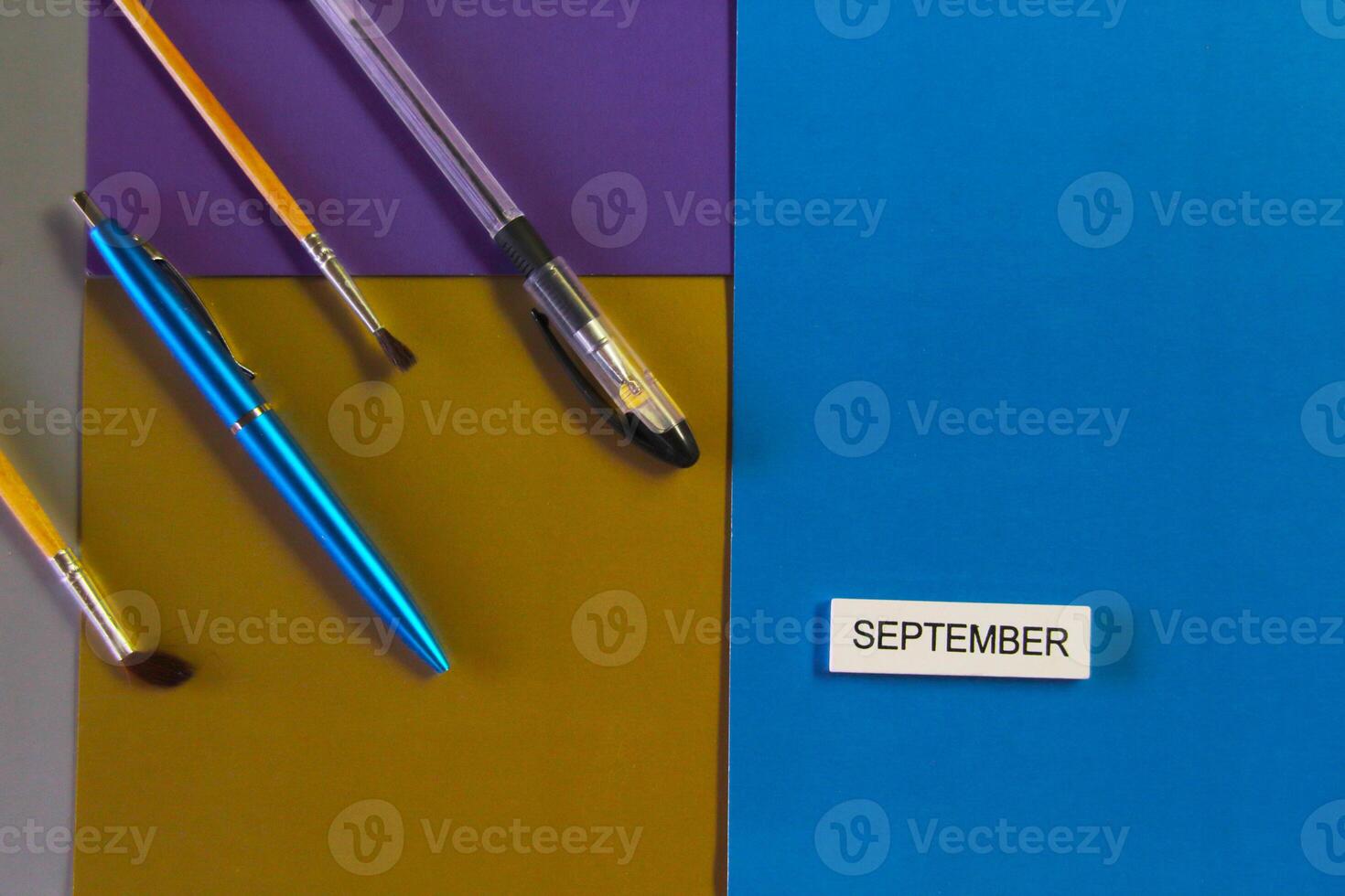 Stationery and a sign saying September are on the colored cardboard. Concept of learning photo