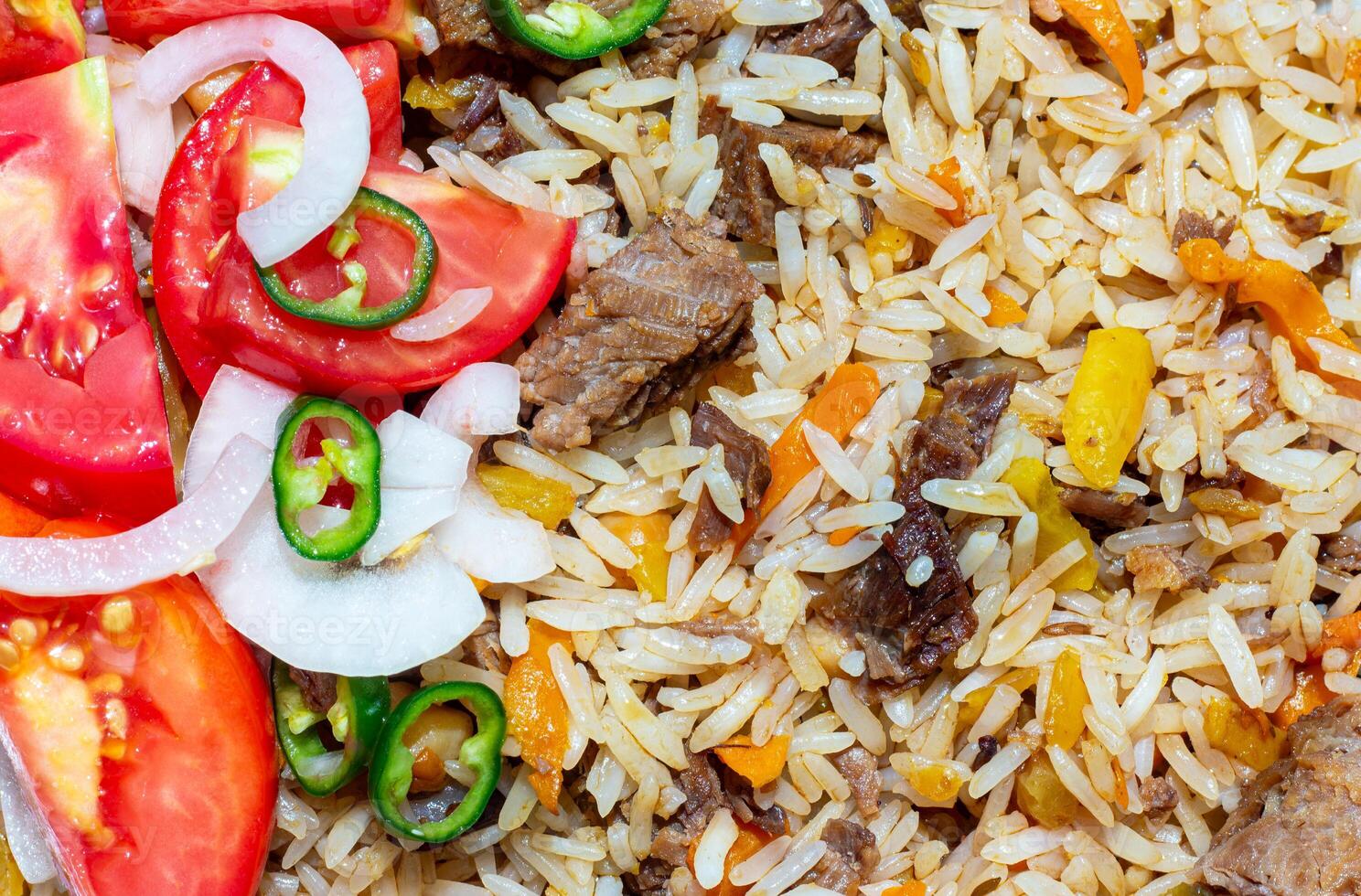 a plate of rice and meat with tomatoes and peppers photo