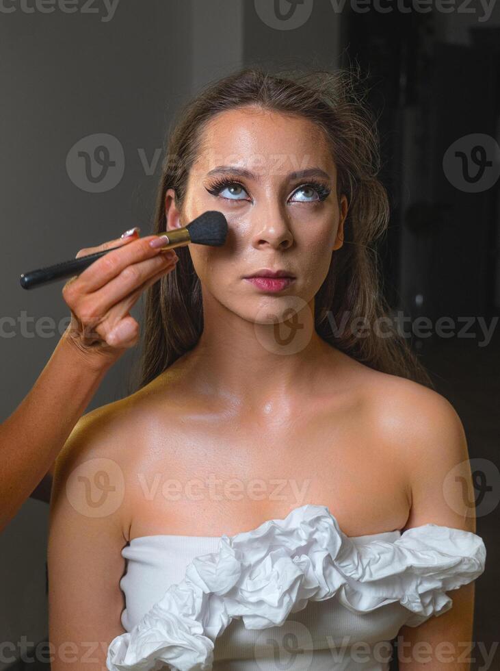 Close up of a smiling woman with radiant makeup. Her soft waves frame her face beautifully photo