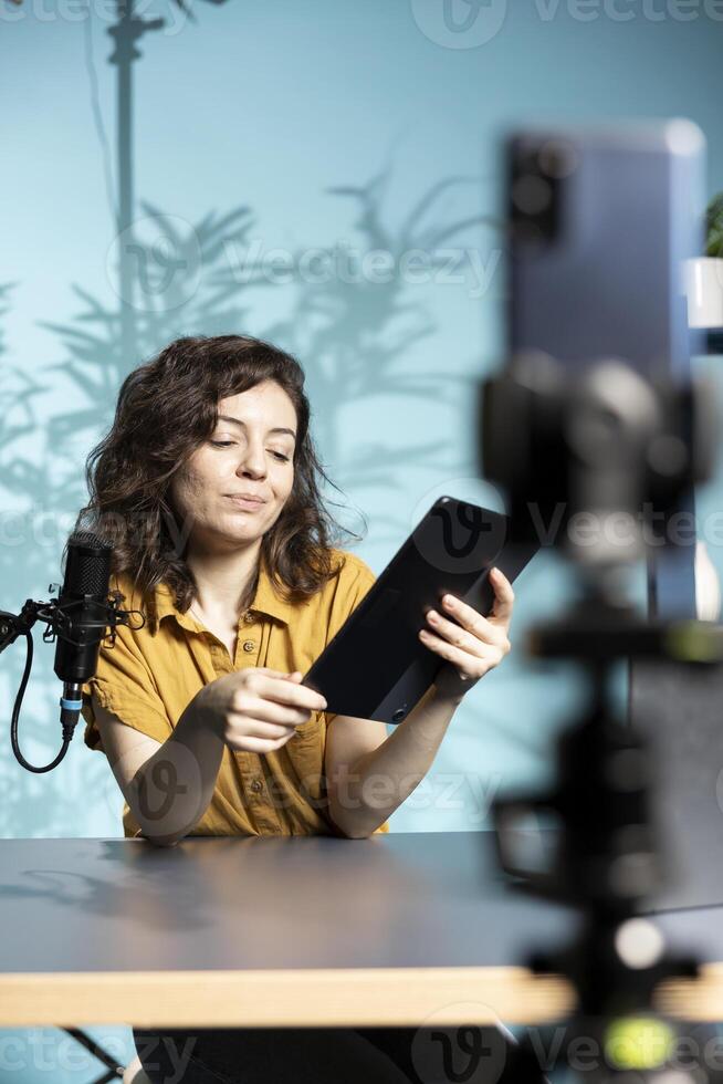 Content creator analyzing newly released gaming tablet received from sponsor, doing honest review for online streaming channel. Media star reviewing digital device from partnering brand photo