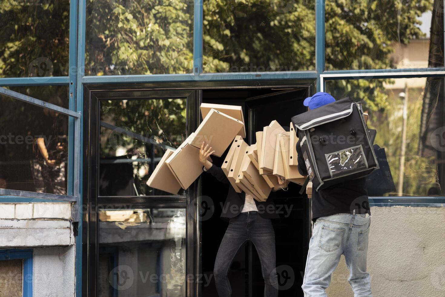Takeaway courier drops multiple pizza boxes while approaching front door. The meal order spills across the sidewalk as a client looks on, dissatisfied with the clumsy and careless food service. photo