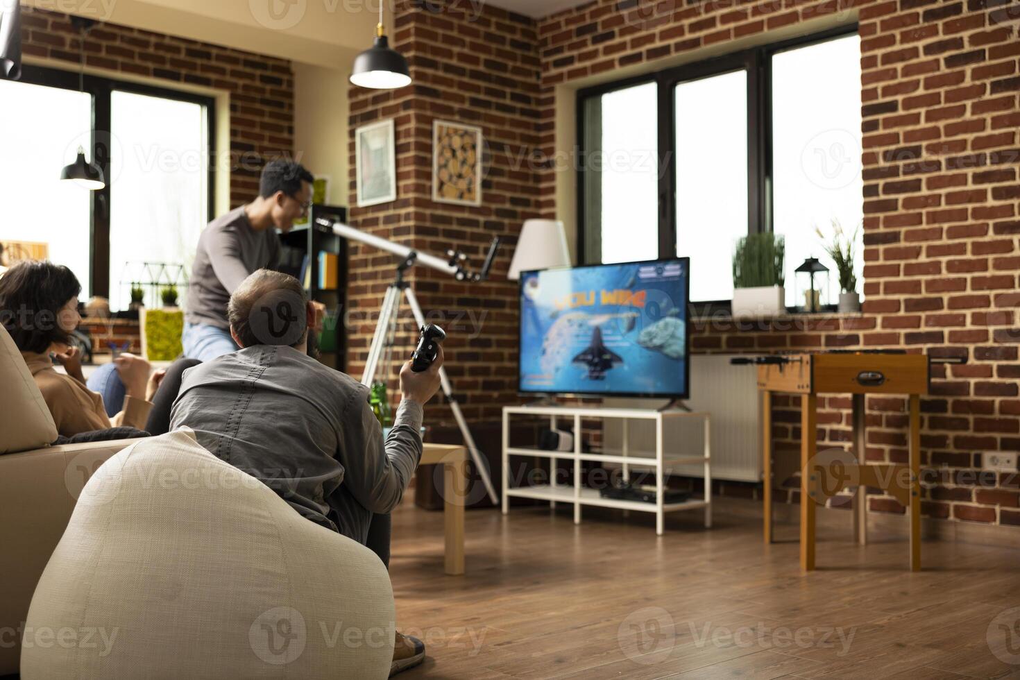 Diverse people bonding over successful game session, sharing smiles and cheers after win. Group of friends seated with gaming controllers, drinks and snacks nearby, filled with excitement. photo