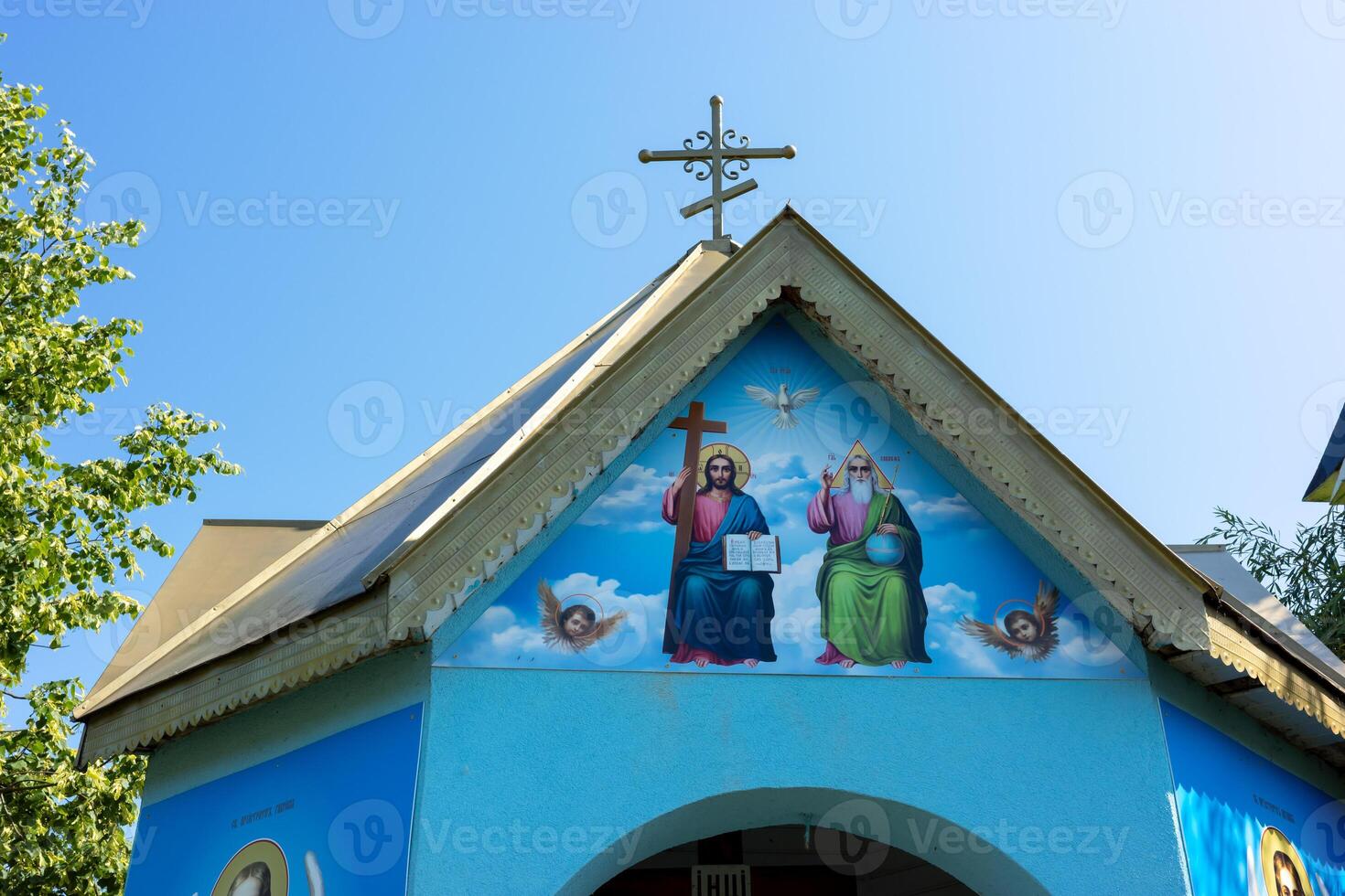 Chapel in Teresva showcases vibrant religious artwork under a clear blue sky photo