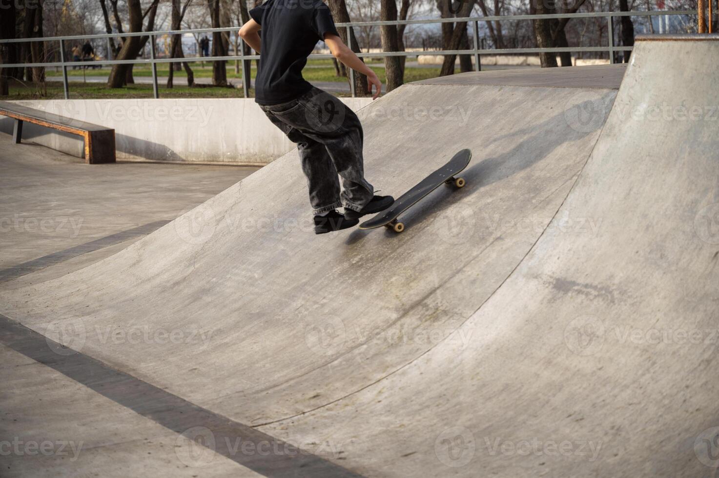 An unrecognizable skateboarder stands on a skateboard photo