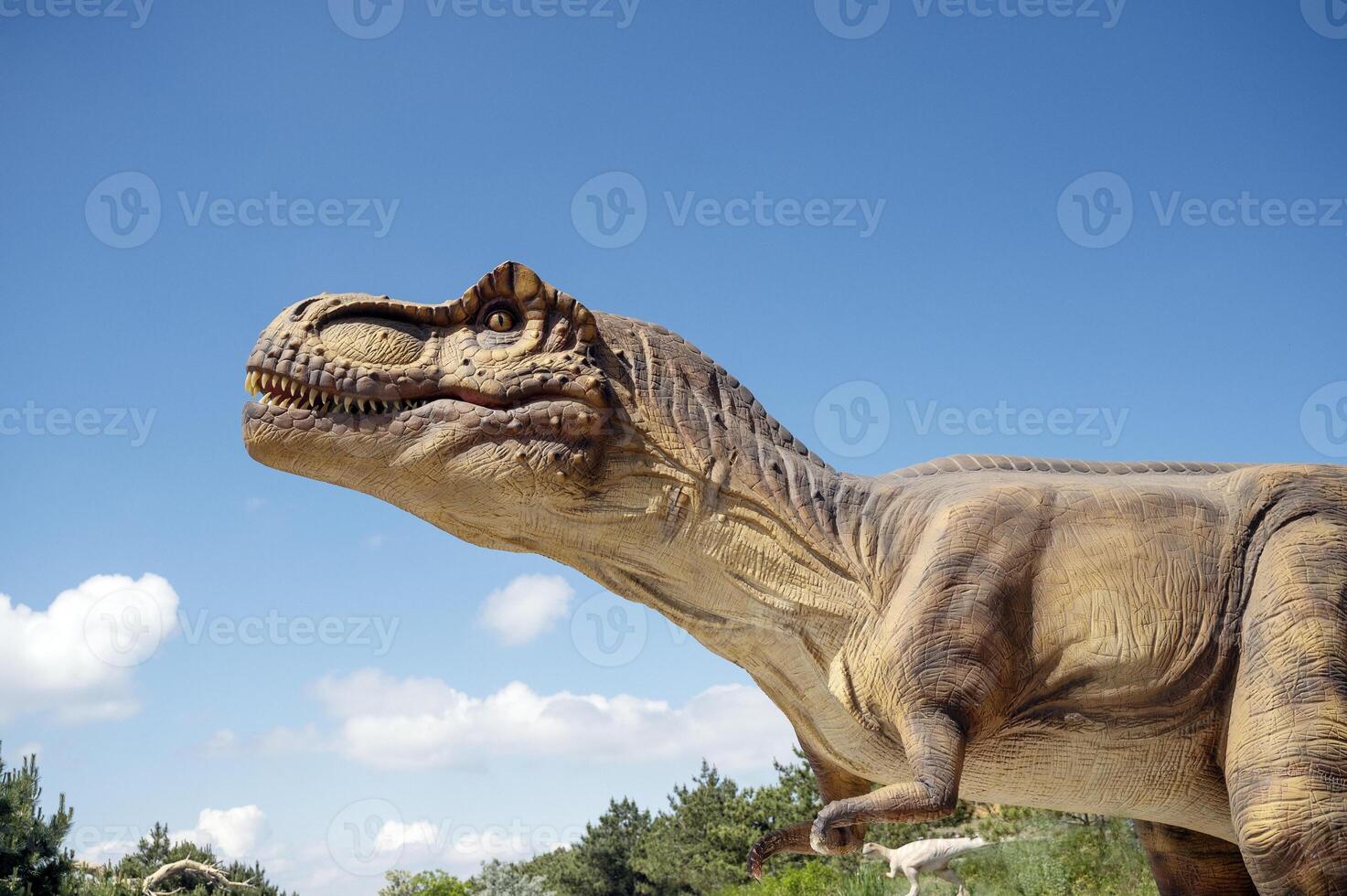 Artificial dinosaur tyrannosaurus, close-up of dinosaur head against sky background photo