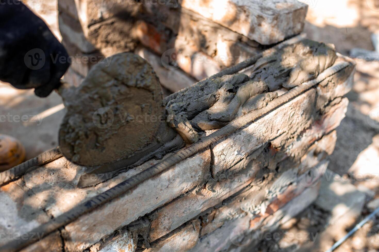 applying wet cement to brick structure showing texture and process of barbecue construction photo