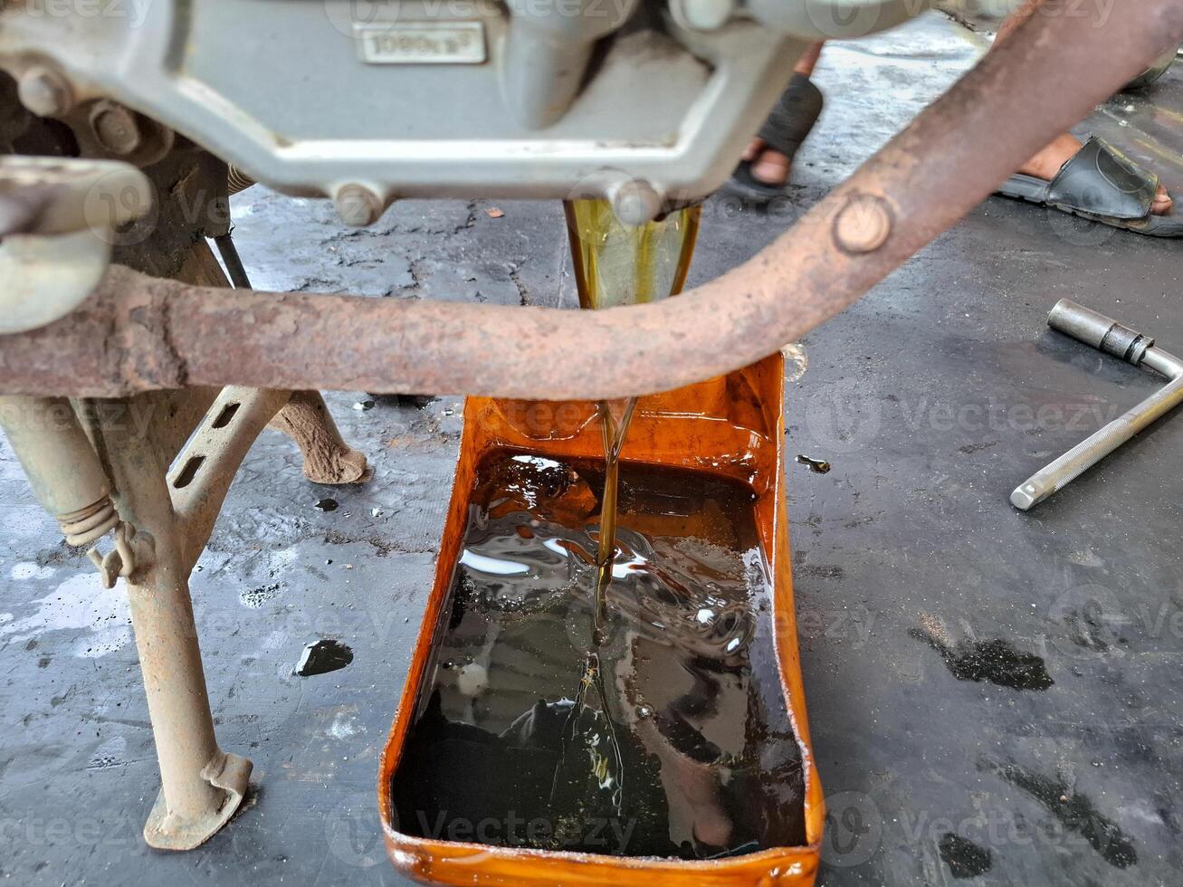 the process of changing the oil in a motor vehicle by the old oil photo