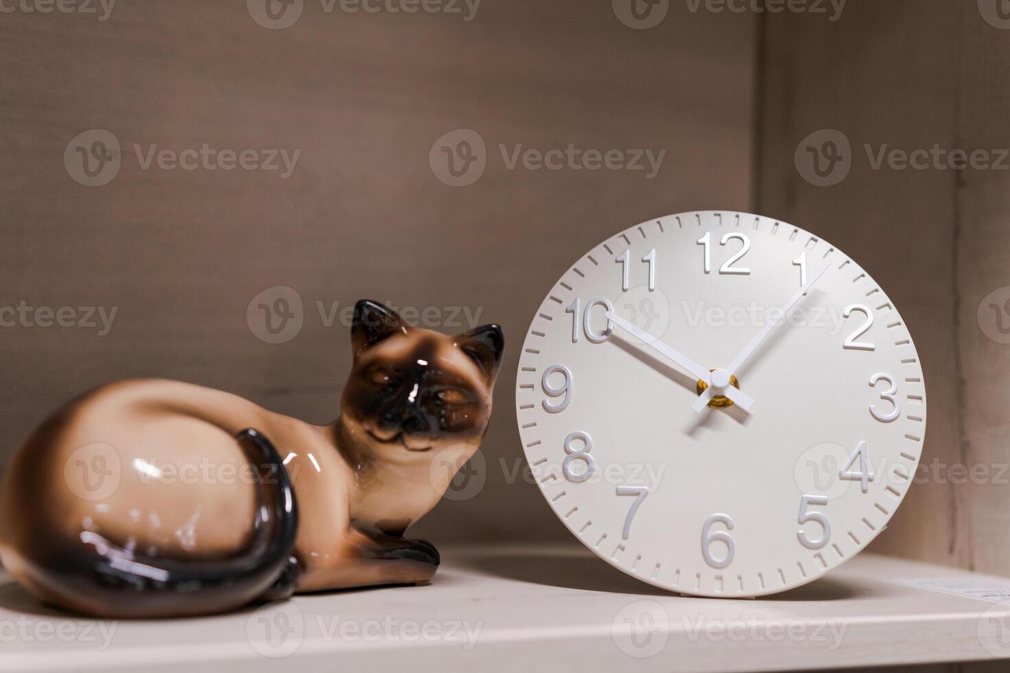 white clock and cat figurine stand on a shelf, home decor photo
