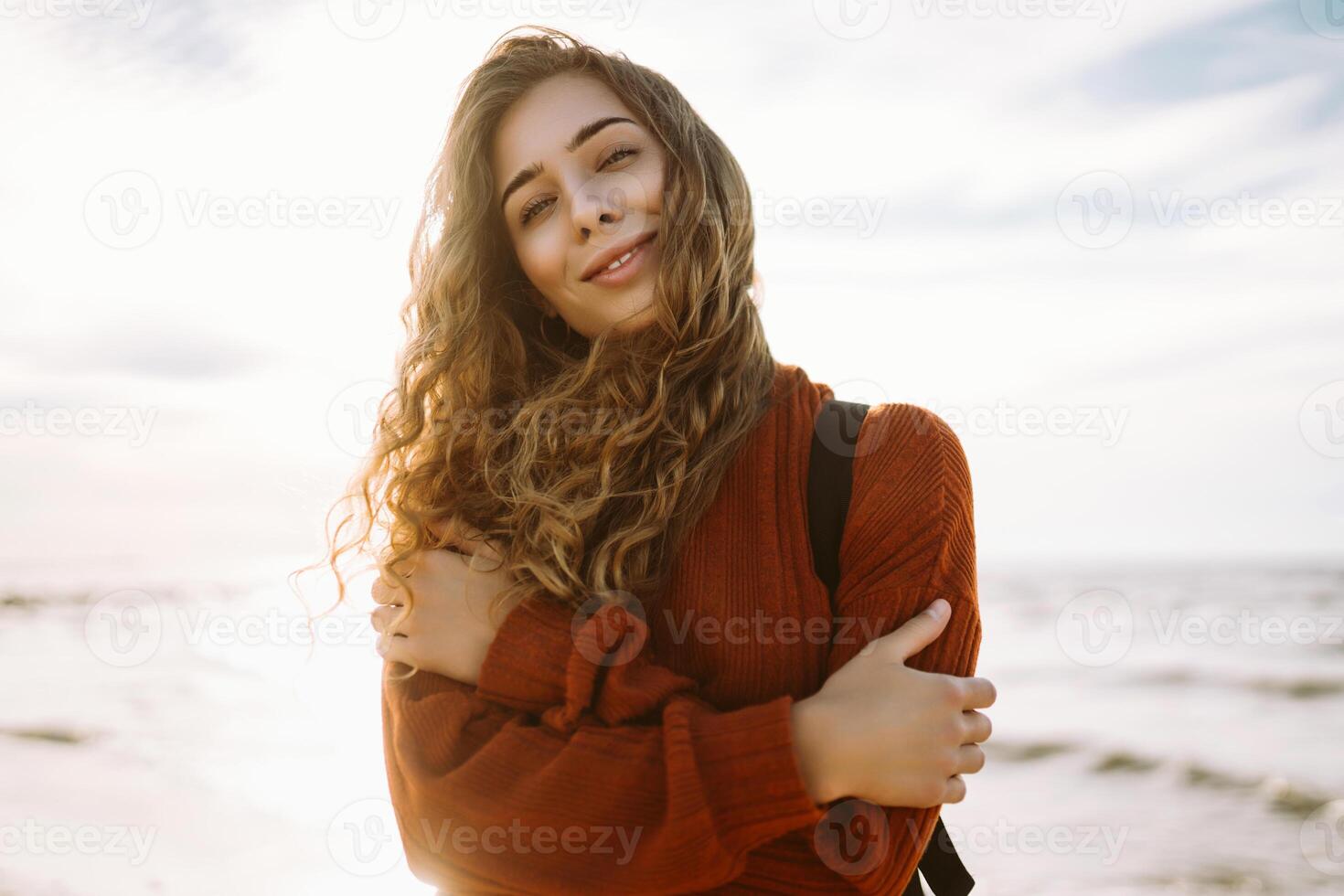 Enjoying breezy day near vibrant red lighthouse at sunset. Travel, weekend, lifestyle concept. photo