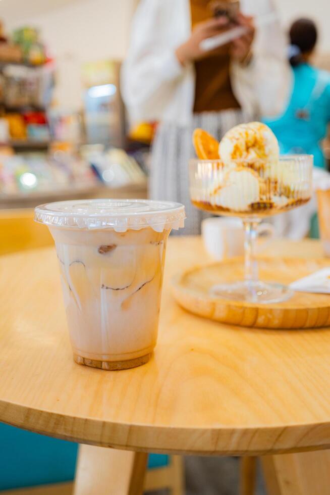 Close up glass ice coffee on wooden table at coffee shop in copy space concept. photo