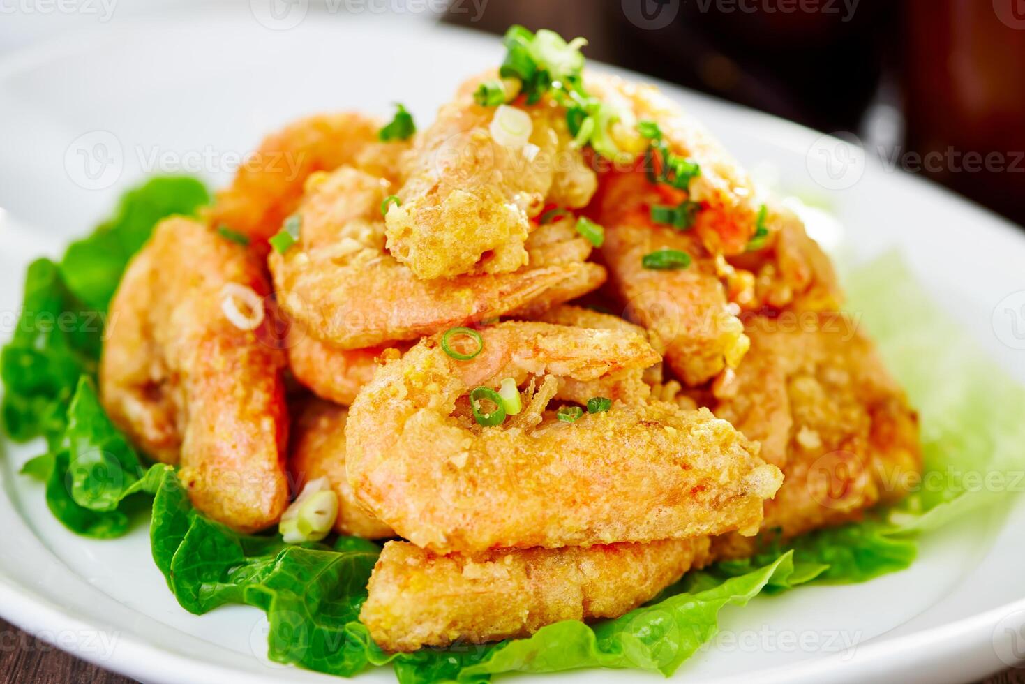 Crispy Golden Fried Shrimp Balls on Lettuce, Garnished with Scallions served in plate closeup side view of Asian Dish photo