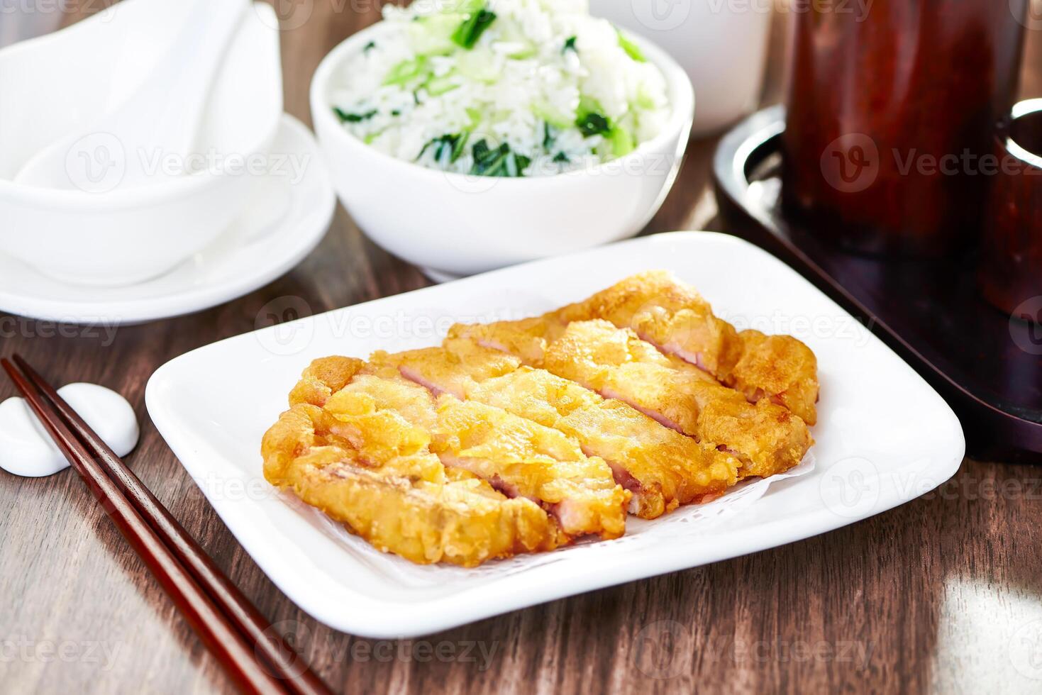 Crispy Fried Pork Chop with Vegetable Rice with chopsticks served in dish side view of Classic Chinese Comfort Food Meal photo