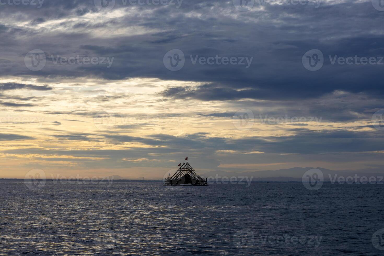 Traditional Floating Fishing Structure at Sunrise Over Calm Sea photo