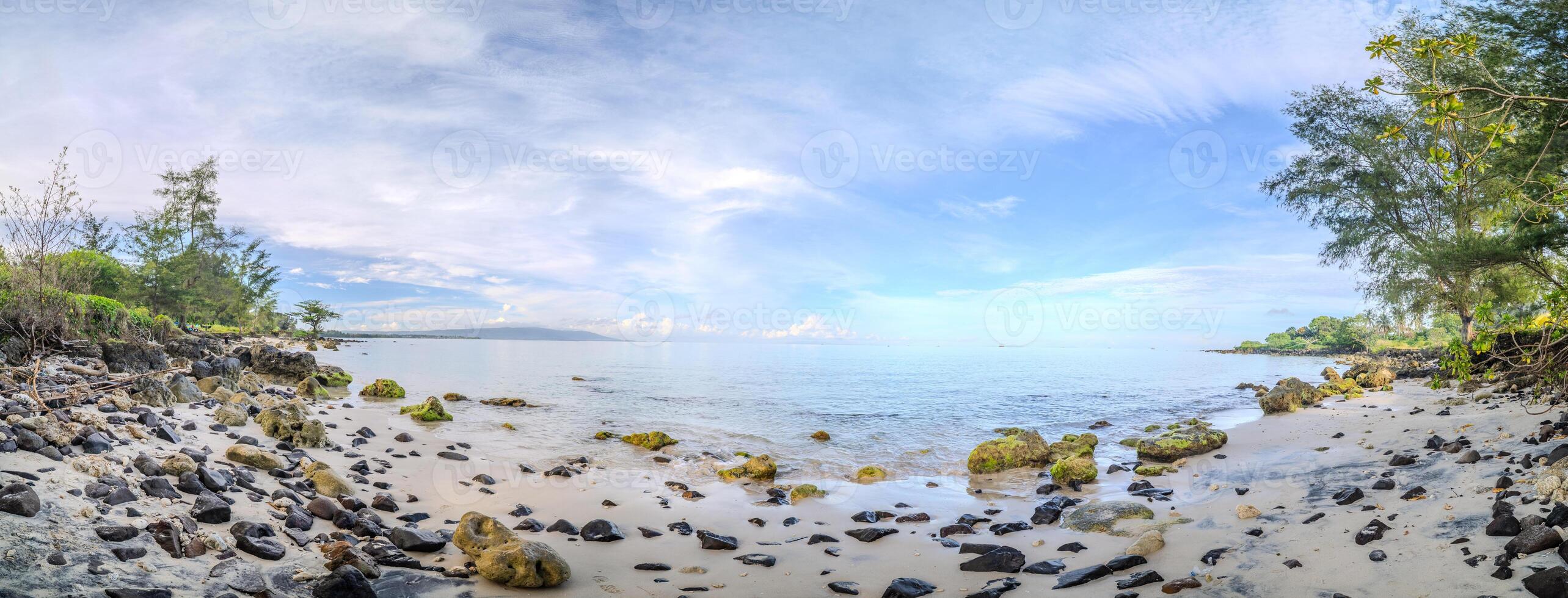 Rocky Tropical Beach Under Blue Sky. Scenic Coastal View on Remote Tropical Shoreline photo