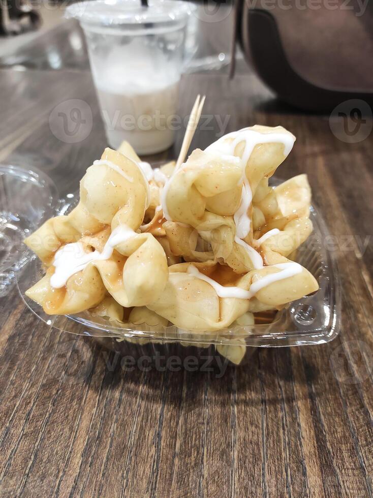Tabletop shot of crispy mayonnaise dumplings. A very crispy and delicious fried food. A light snack. Tasty gourmet served on a wooden table with two toothpicks. Fried snack. Negative space photo