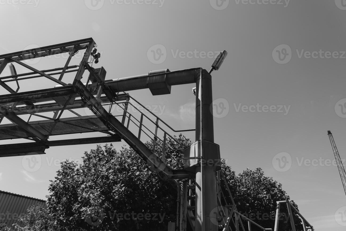 Sturdy construction framework rises against a bright sky while a crane looms in the background during a sunny afternoon photo