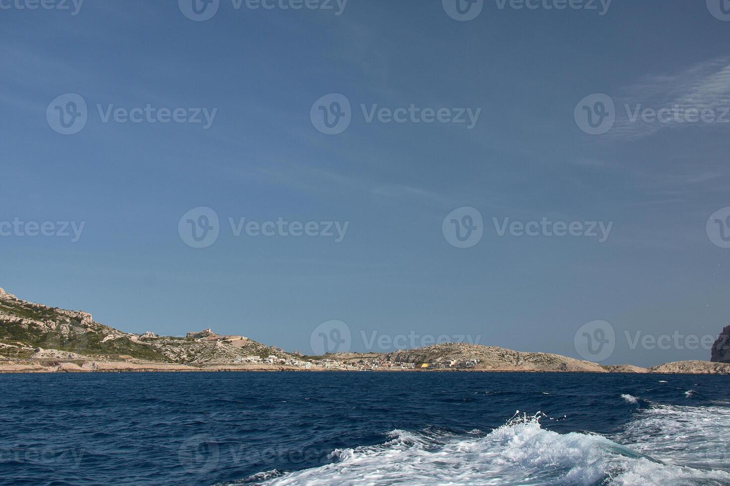 Sailing experience in front of the cliffs of the Calanques in Marseille, with sea spray and a clear horizon photo