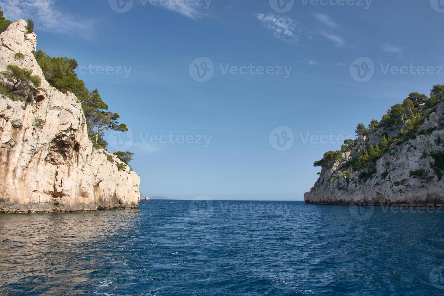 Coastal landscape of the Calanques de Marseille from the perspective of a boat, with clear skies and calm seas photo