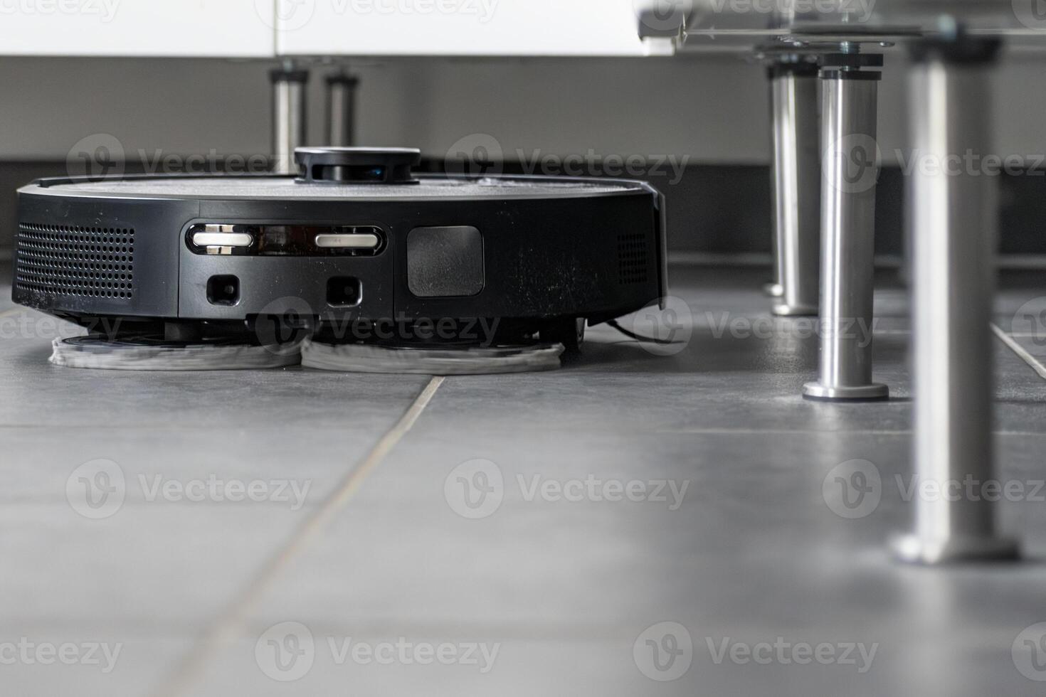 Robot vacuum cleaner with dust, real life photo, saves time and goes into hard-to-reach places photo