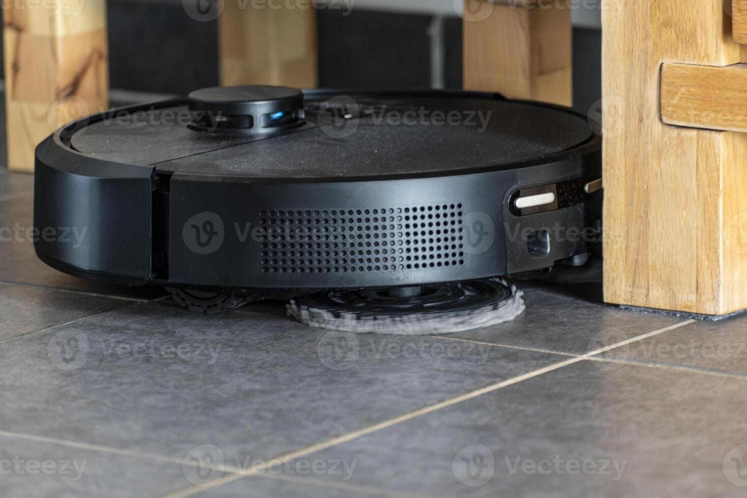 Robot vacuum cleaner with dust, real life photo, saves time and goes into hard-to-reach places, cleaning photo