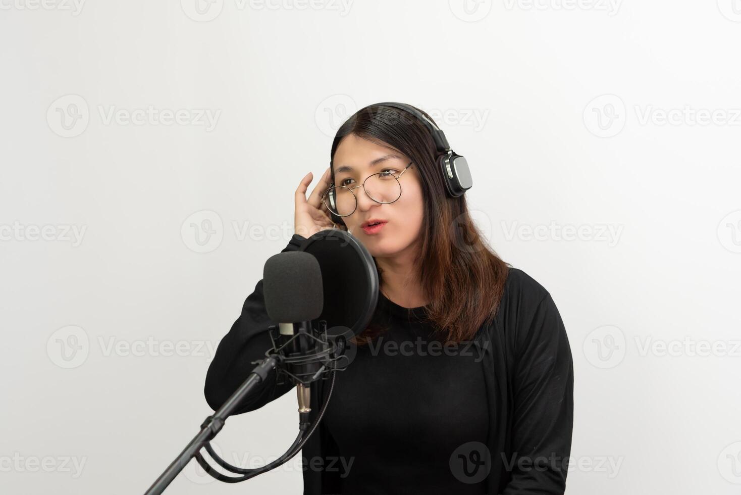 Asian woman in black shirt and glasses holding microphone and recording photo