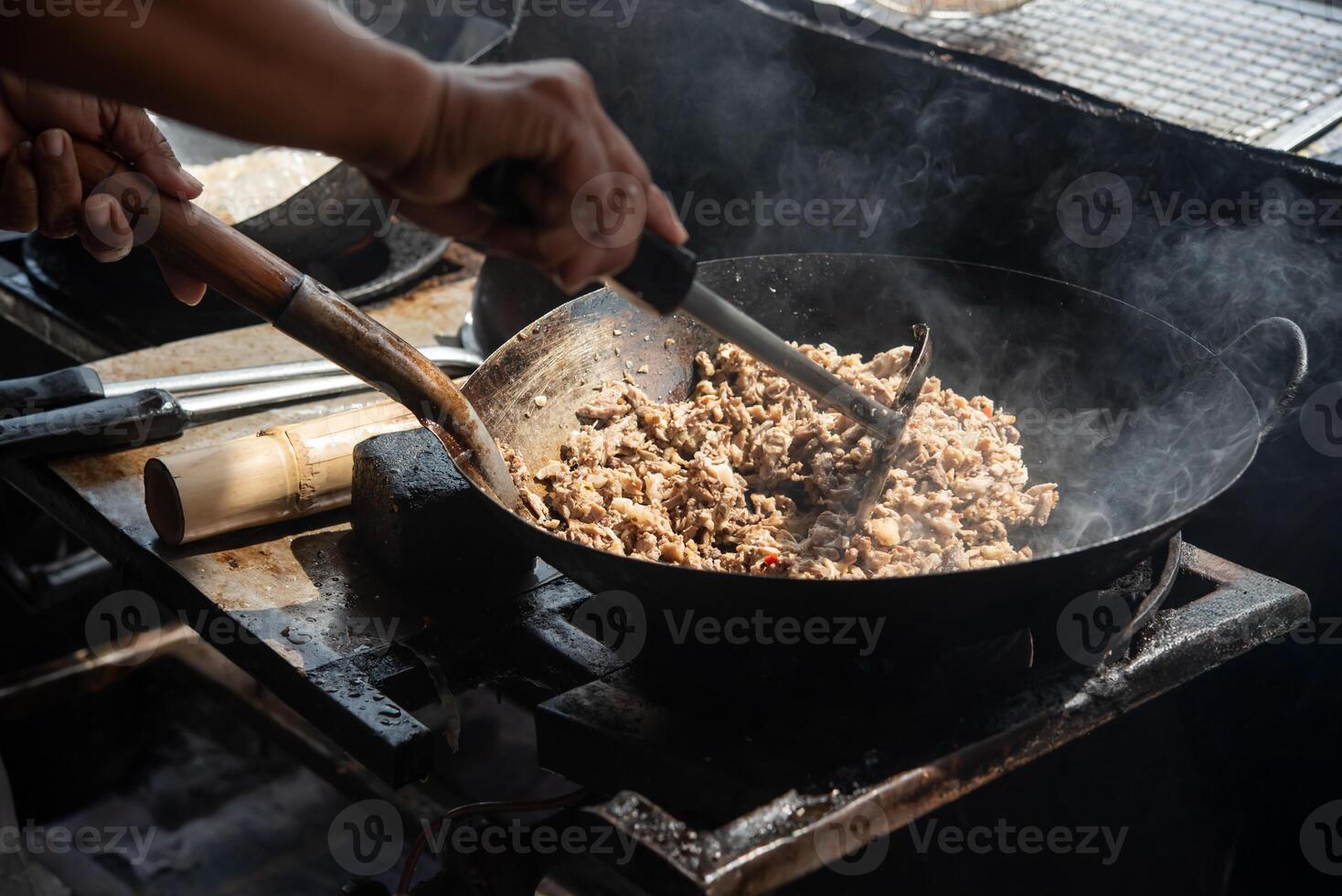 A person stirring a pan of food on a stove photo