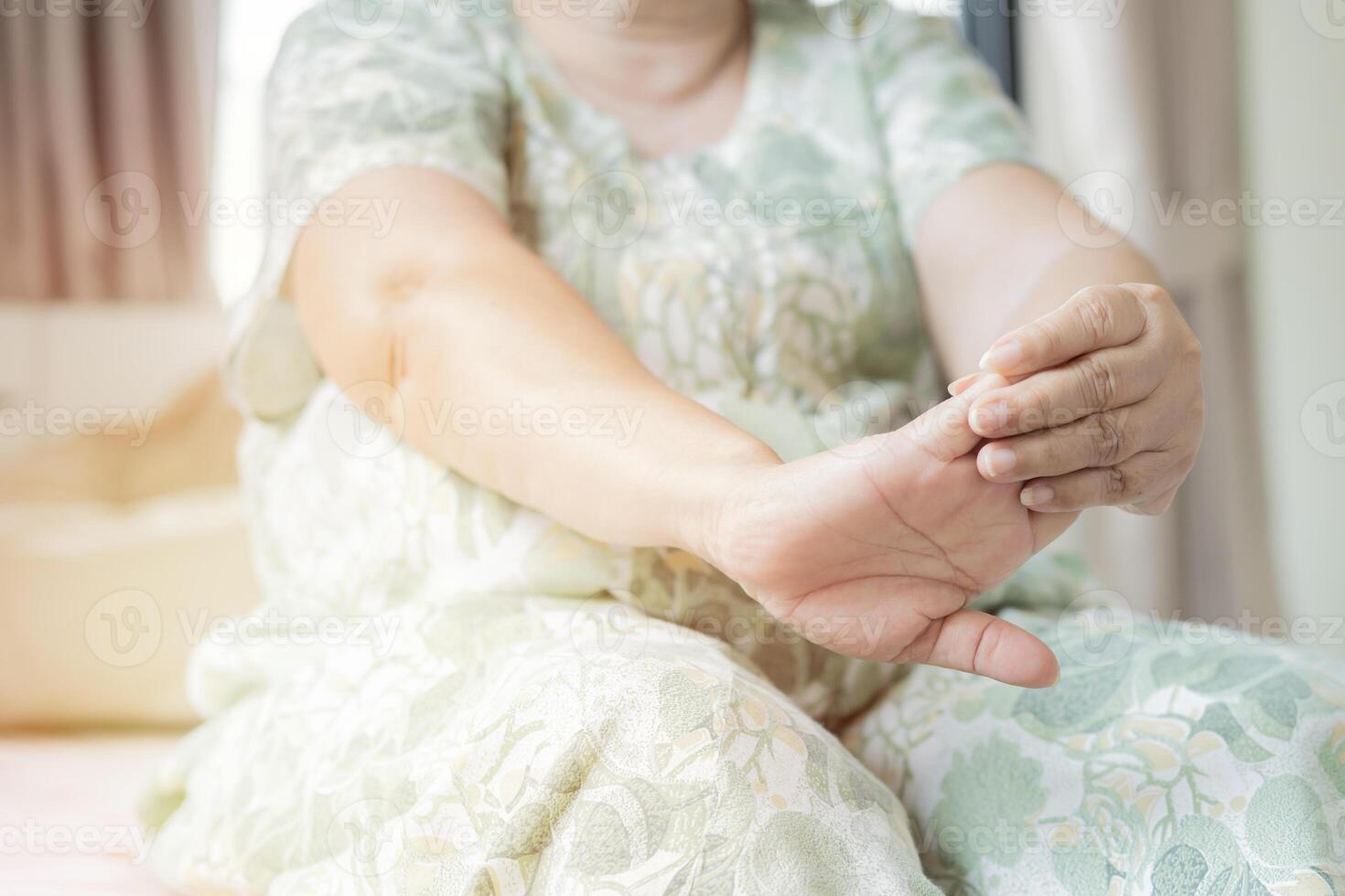 Older woman during a physiotherapy treatment one her hands at bedroom in the morning. photo