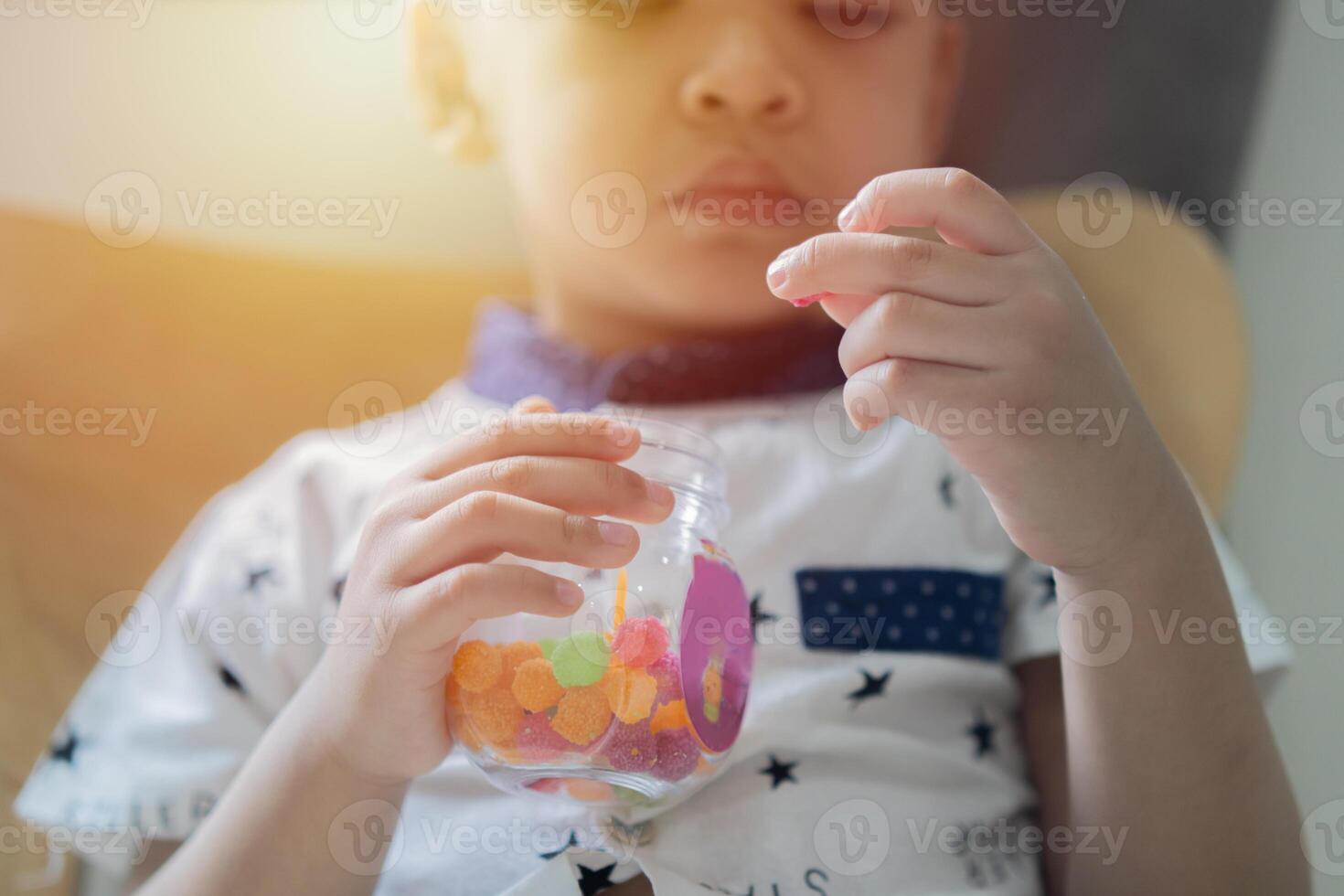 Gummy ball, kid has a good appetite, happy childhood, Close-up hands of child boy want to eat a sweet candy. photo