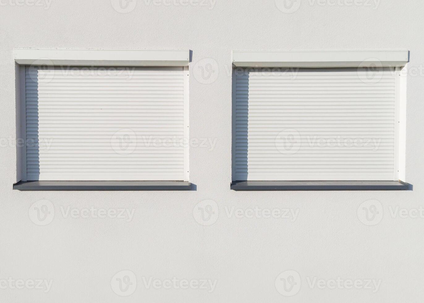 Two Closed Window Shutters on White Wall photo