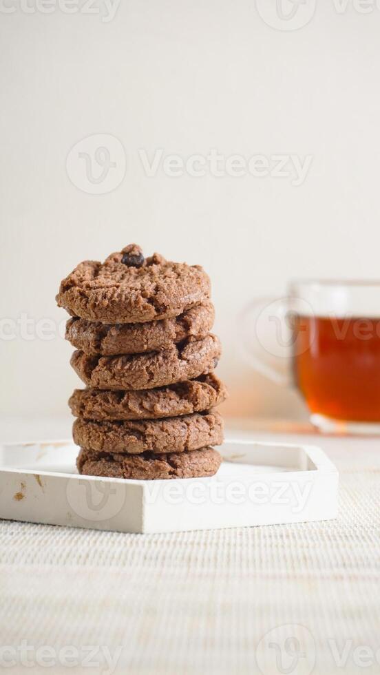 Stack of chocolate cookies on a white plate isolated on light background photo