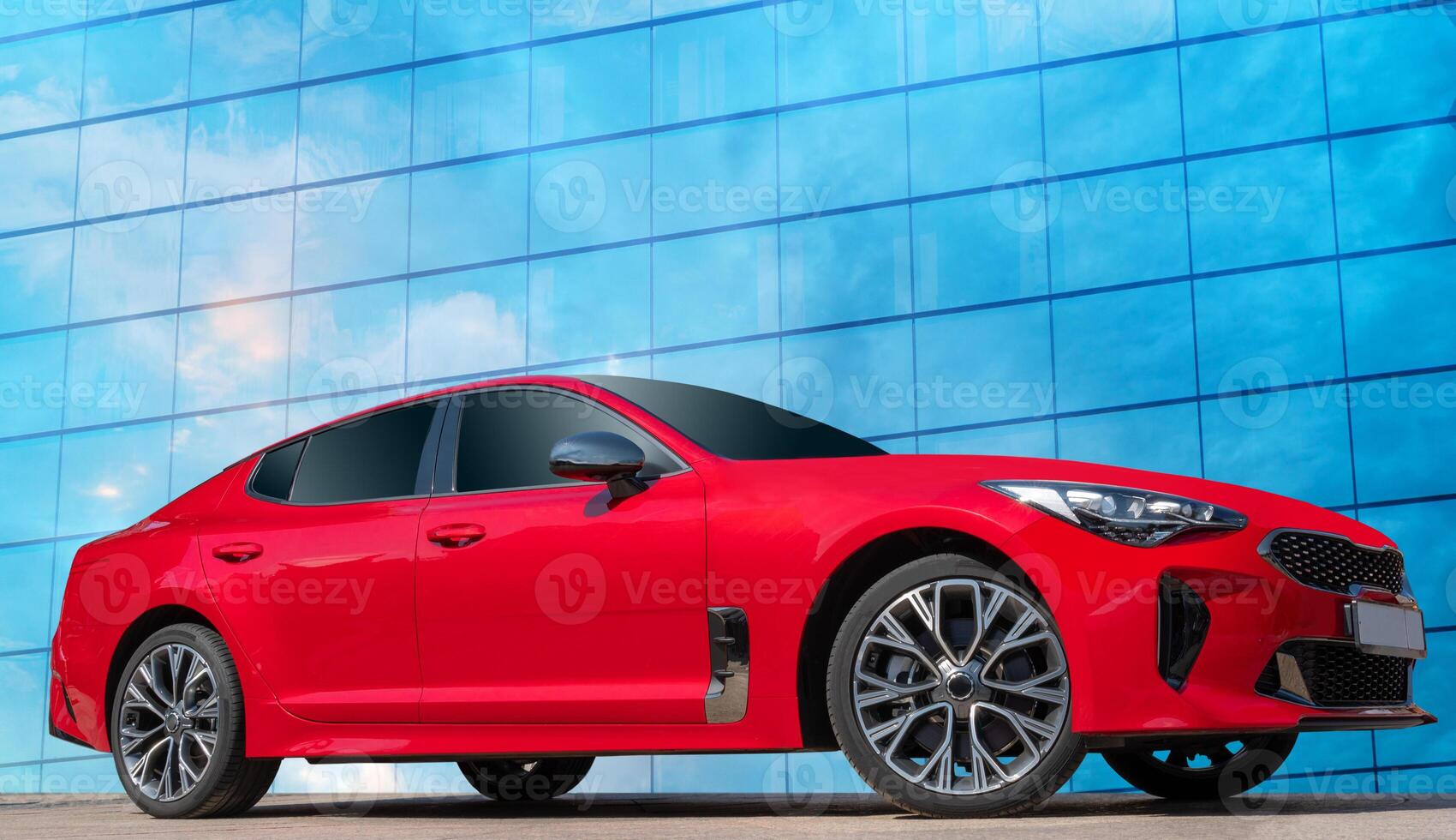 Red car on a blue sky background with white clouds. Wonderful car on a blue background. A stylish, modern, bright image of an avto mobile for design solutions. photo