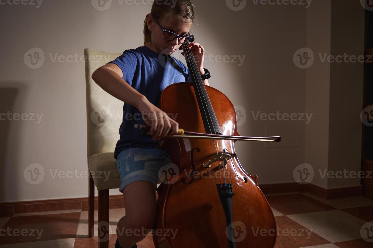 Child Practicing Cello at Home in Quiet Room photo