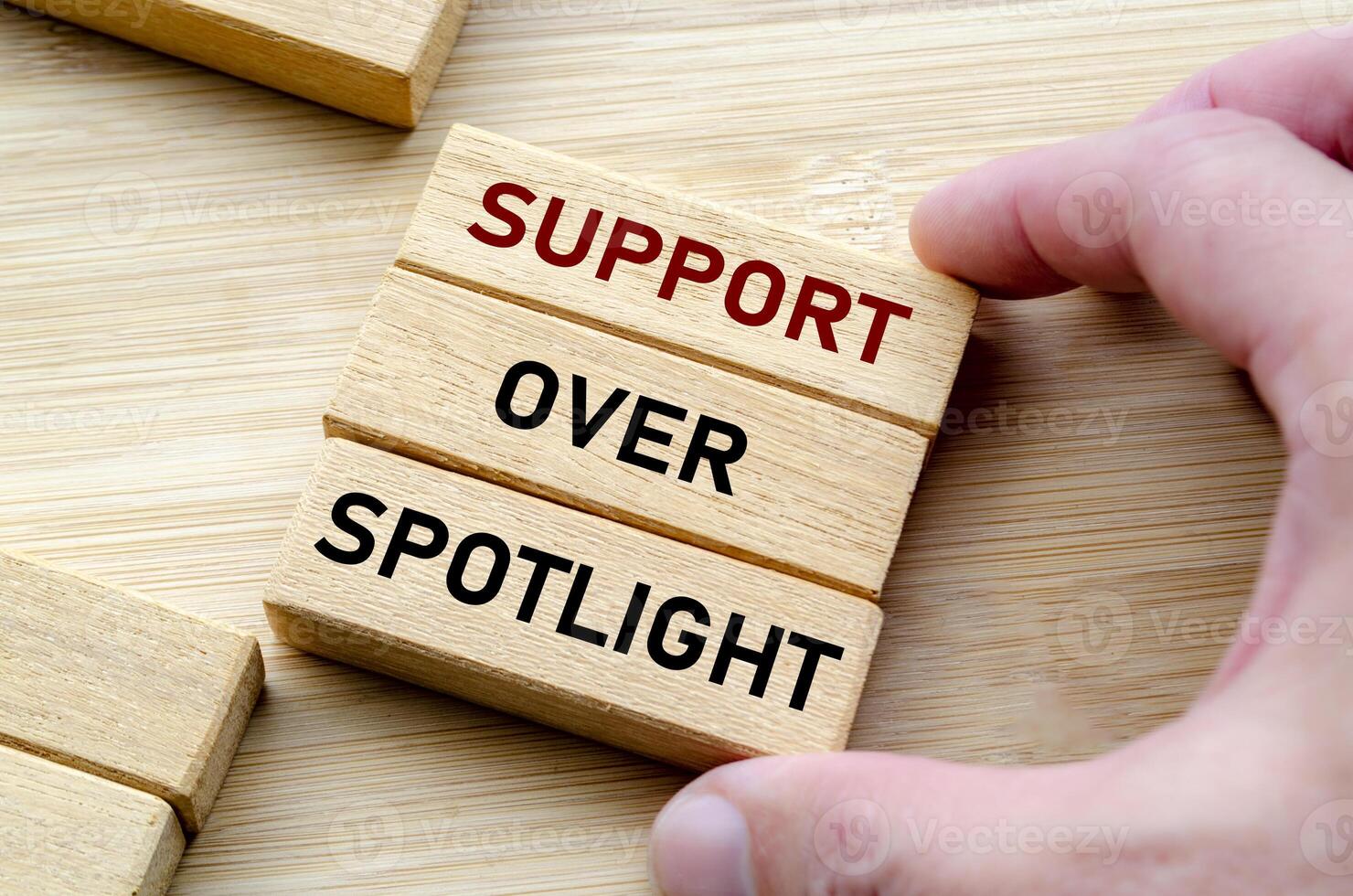 Support over spotlight text on wooden block. photo