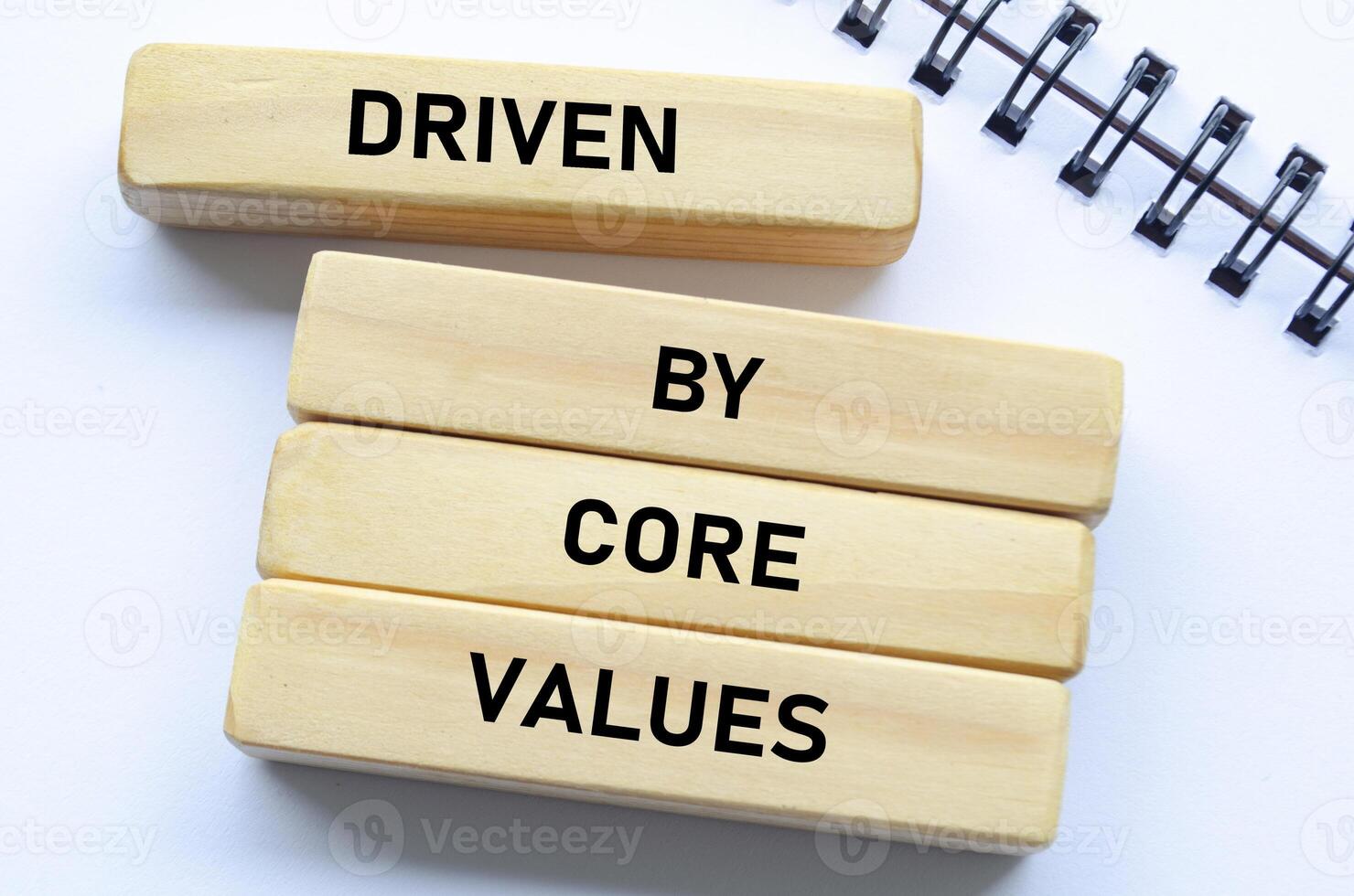 Driven by core values text on wooden blocks and notebook represents purposeful direction guided by foundational beliefs photo