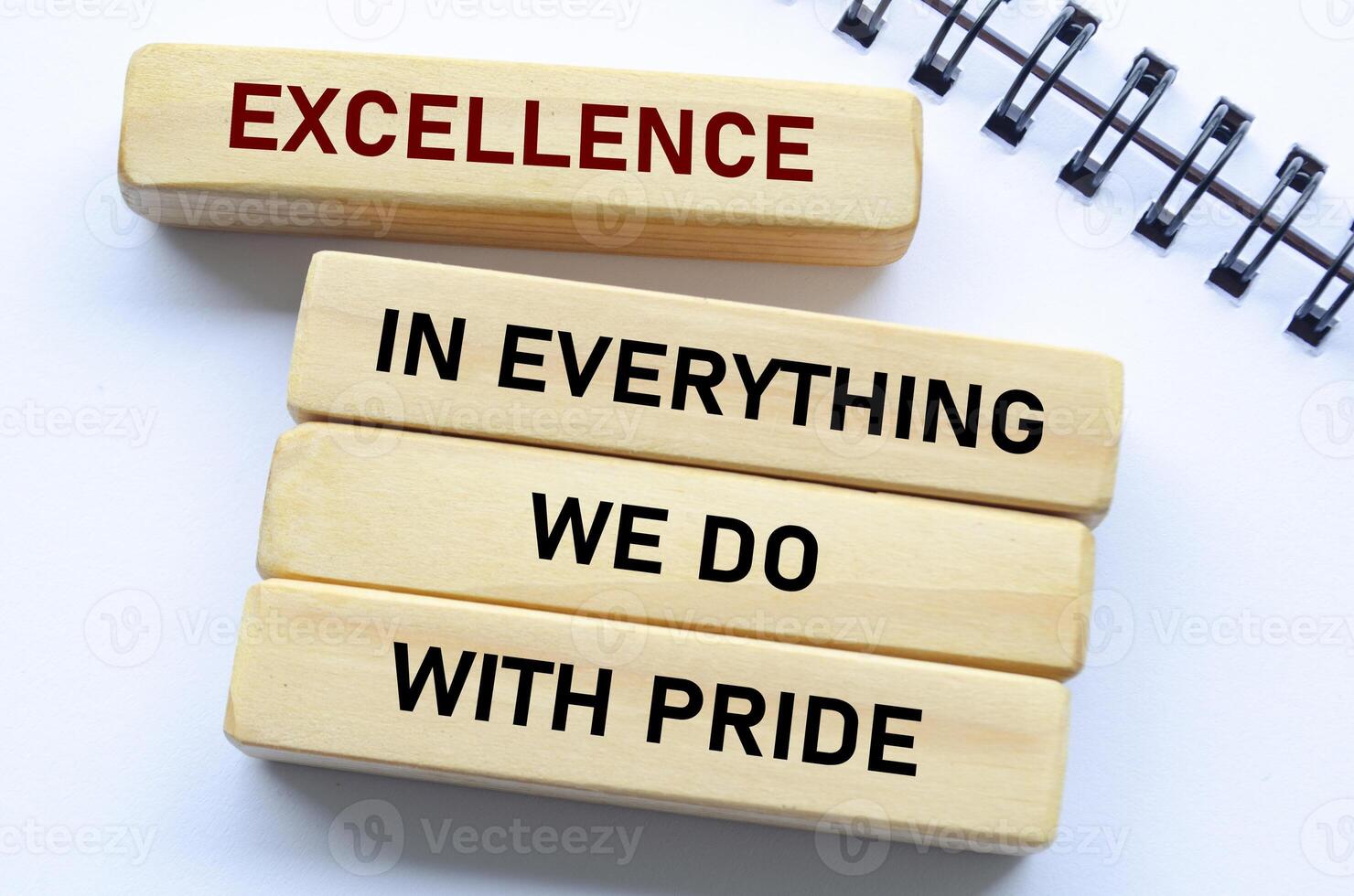Excellence in everything we do with pride text on wooden blocks and notebook reflects unwavering quality and pride in every action photo