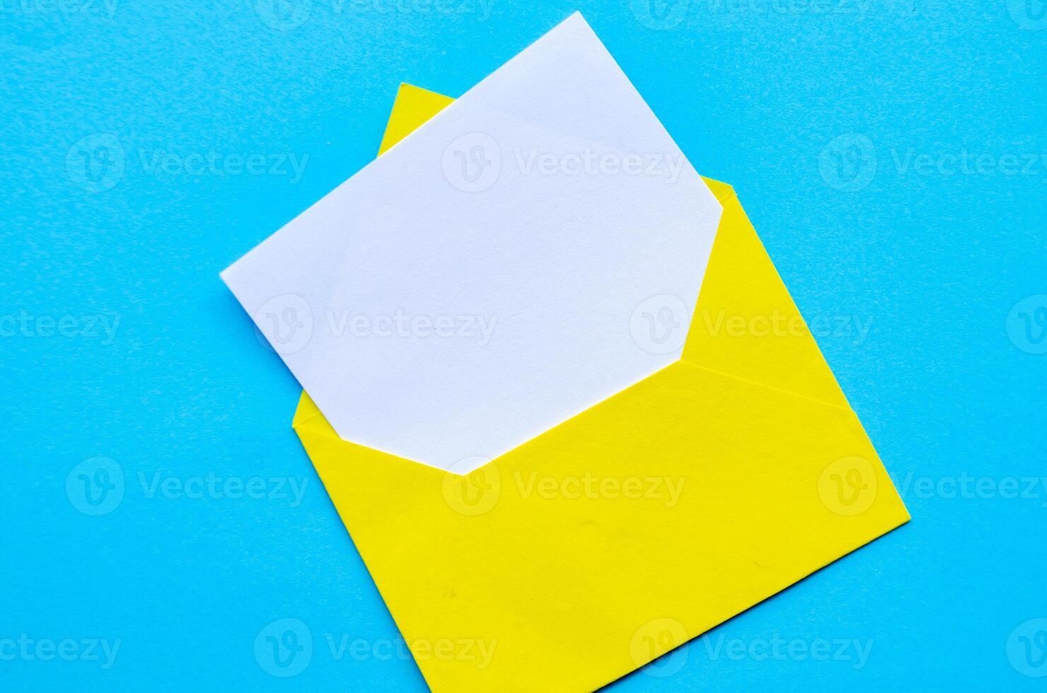 Top view of white notepad with envelope on blue cover background with customizable space for text or ideas. photo