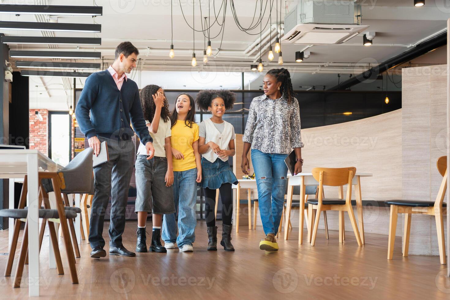 Diverse Group of Kids and Adults Walking Through a Modern Office Space, Mentors Guiding Young Students on a Tour of a Workplace, Happy Children Learning and Exploring in a Professional Environment photo