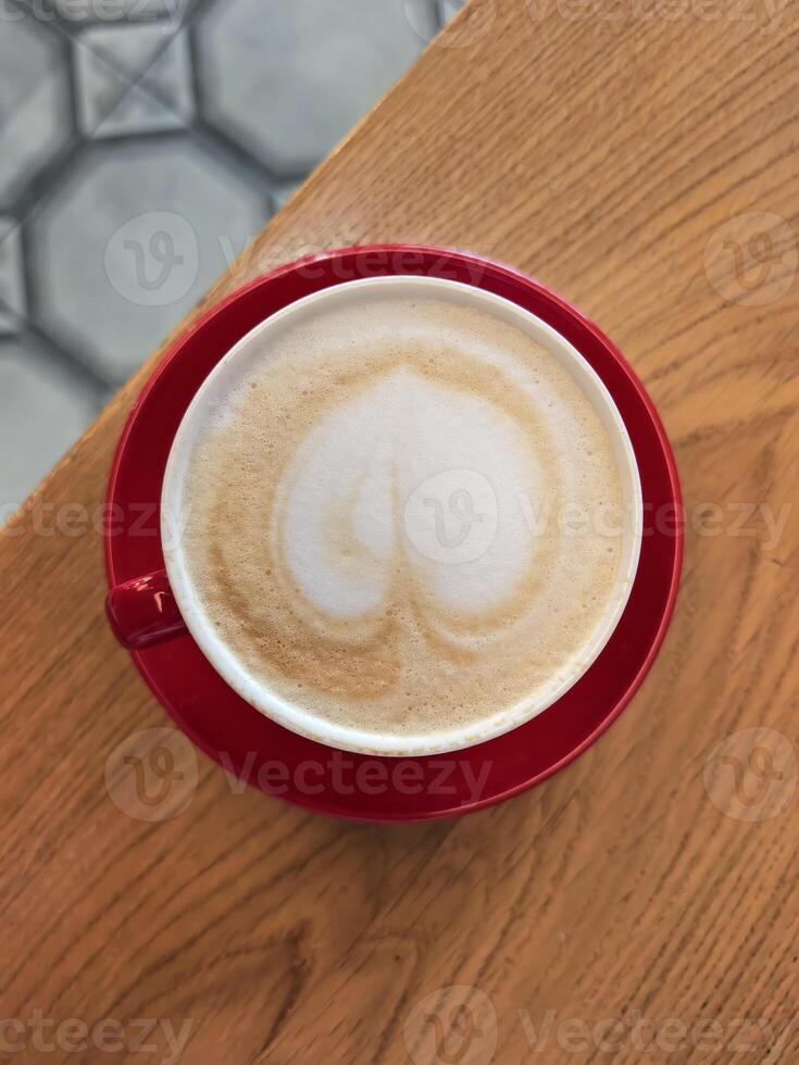 Cappuccino with Heart Latte Art in Red Cup on Table photo