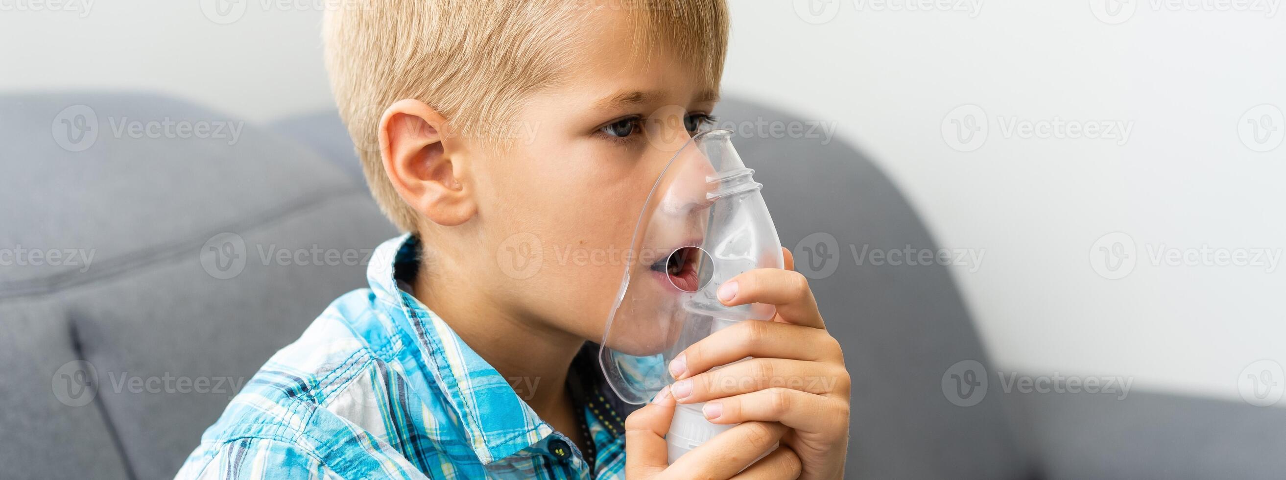 Treatment at home of a toddler. A boy is using nebuliser. photo