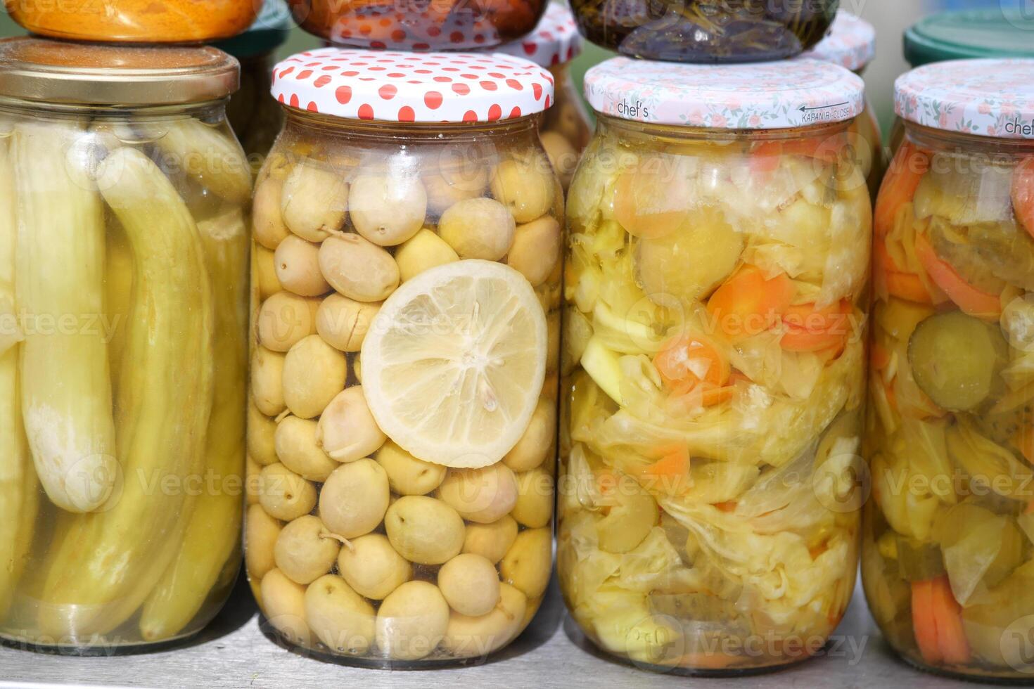 Colorful jars of preserved fruits and vegetables on display photo