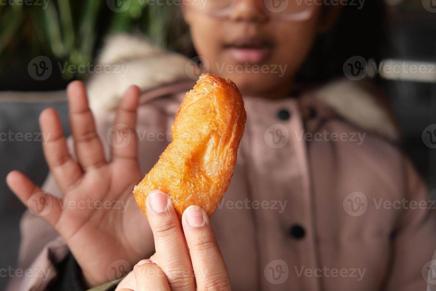 Child enjoys a crispy treat at a local eatery in winter photo