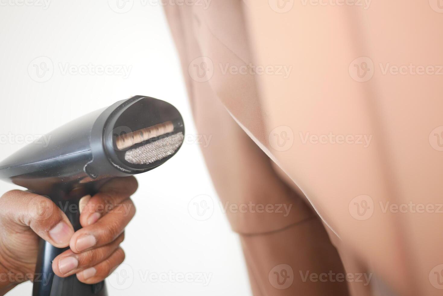 Steaming wrinkles from a brown suit in a bright room photo