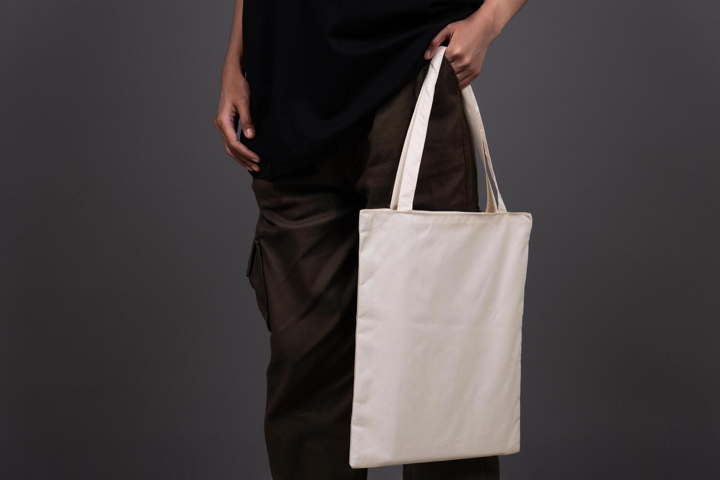 Front View of Woman Holding Blank Canvas Tote Bag, Eco-Friendly Reusable Fabric with Handle, Close-Up Mockup, No Plastic and Environmental Concept Fashion photo