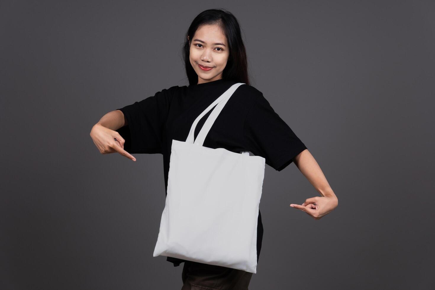 Front View of Woman Holding Blank Canvas Tote Bag, Eco-Friendly Reusable Fabric with Handle, Close-Up Mockup, No Plastic and Environmental photo