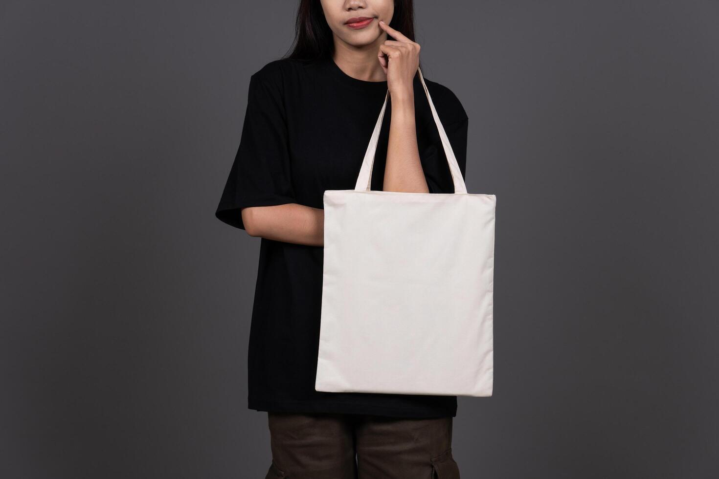 Front View of Woman Holding Blank Canvas Tote Bag, Eco-Friendly Reusable Fabric with Handle, Close-Up Mockup, No Plastic Concept photo