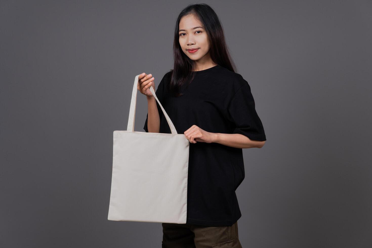 Woman Holding Blank Canvas Tote Bag, Eco-Friendly Reusable Fabric with Handle, Close-Up Mockup, No Plastic and Environmental Concept photo