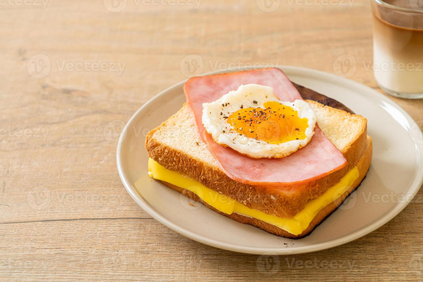 bread toasted cheese topped ham and fried egg with pork sausageon wooden background. photo
