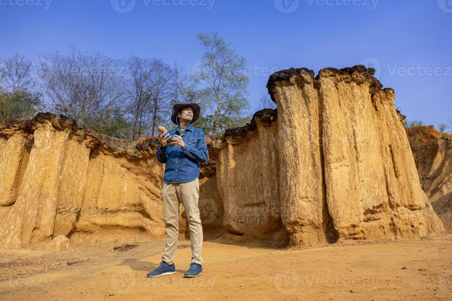 Geologist is exploring and surveying sample rock on the natural sandstone canyon quarry resource site for scientific research and archeology for understanding mother earth photo