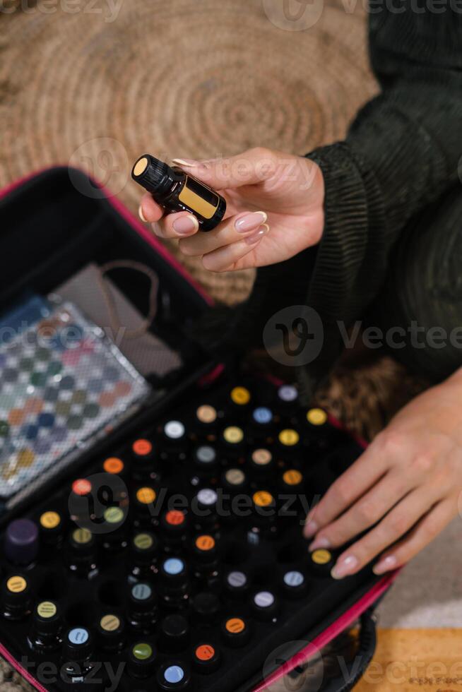 Exploring essential oils in a home setting during a calm afternoon, highlighting various colorful bottles and a person engaged in selecting an oil photo